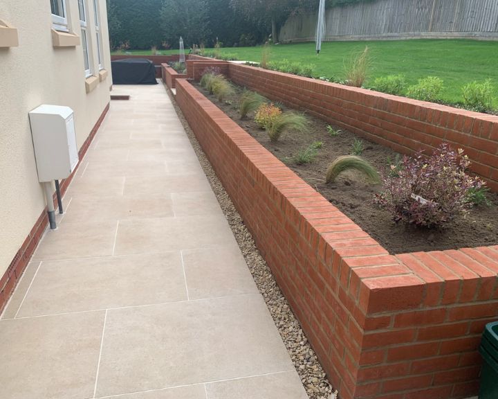 A new garden wall made out of bricks built in a landscaped garden