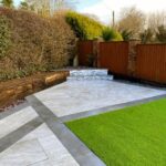 New patio with grey paving slabs installed in a landscaped garden