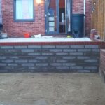 A retaining wall made from brick that has been installed to support a new patio.