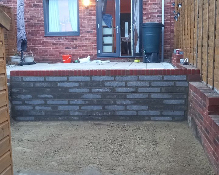A retaining wall made from brick that has been installed to support a new patio.