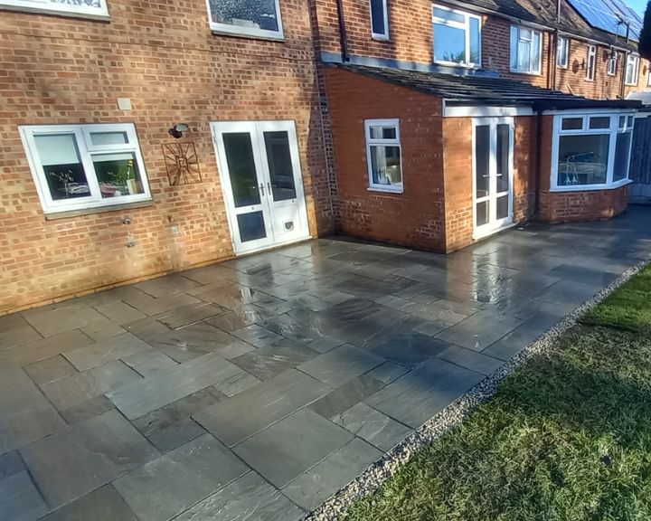 A new patio that has been installed with grey slabs in a garden in Portsmouth.