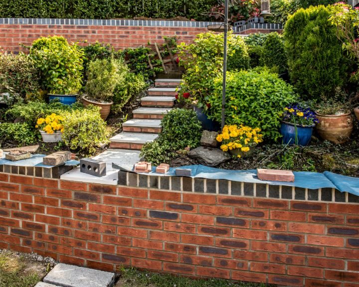 Brick retaining wall being installed in a garden